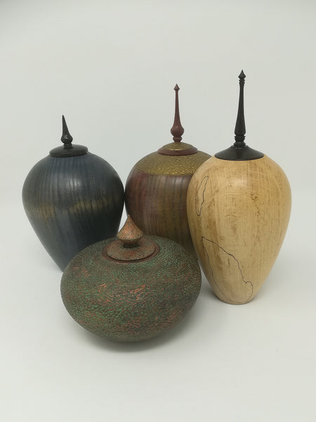 Turned wood ash jar with gold coloured detail and purple heart finial by Roderick Evans.